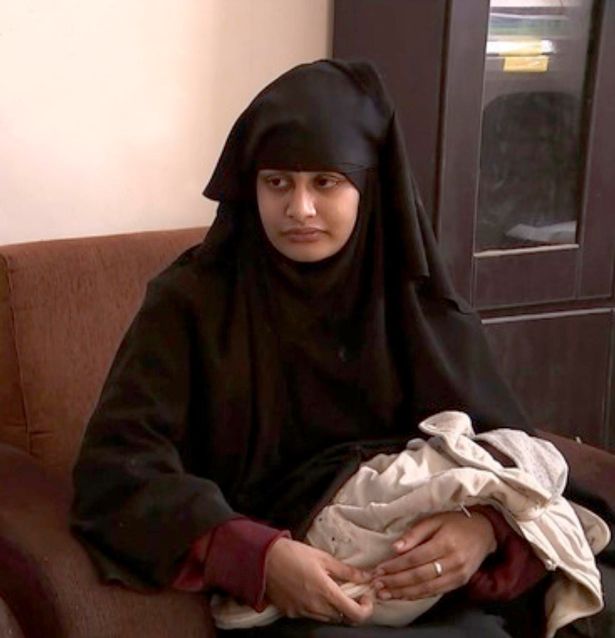 Shamima Begum holds her baby son while speaking to a reporter