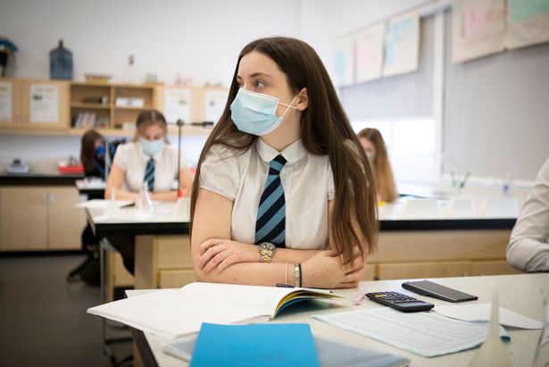 A pupil wears a protective face mask during a chemistry lesson - stock photo